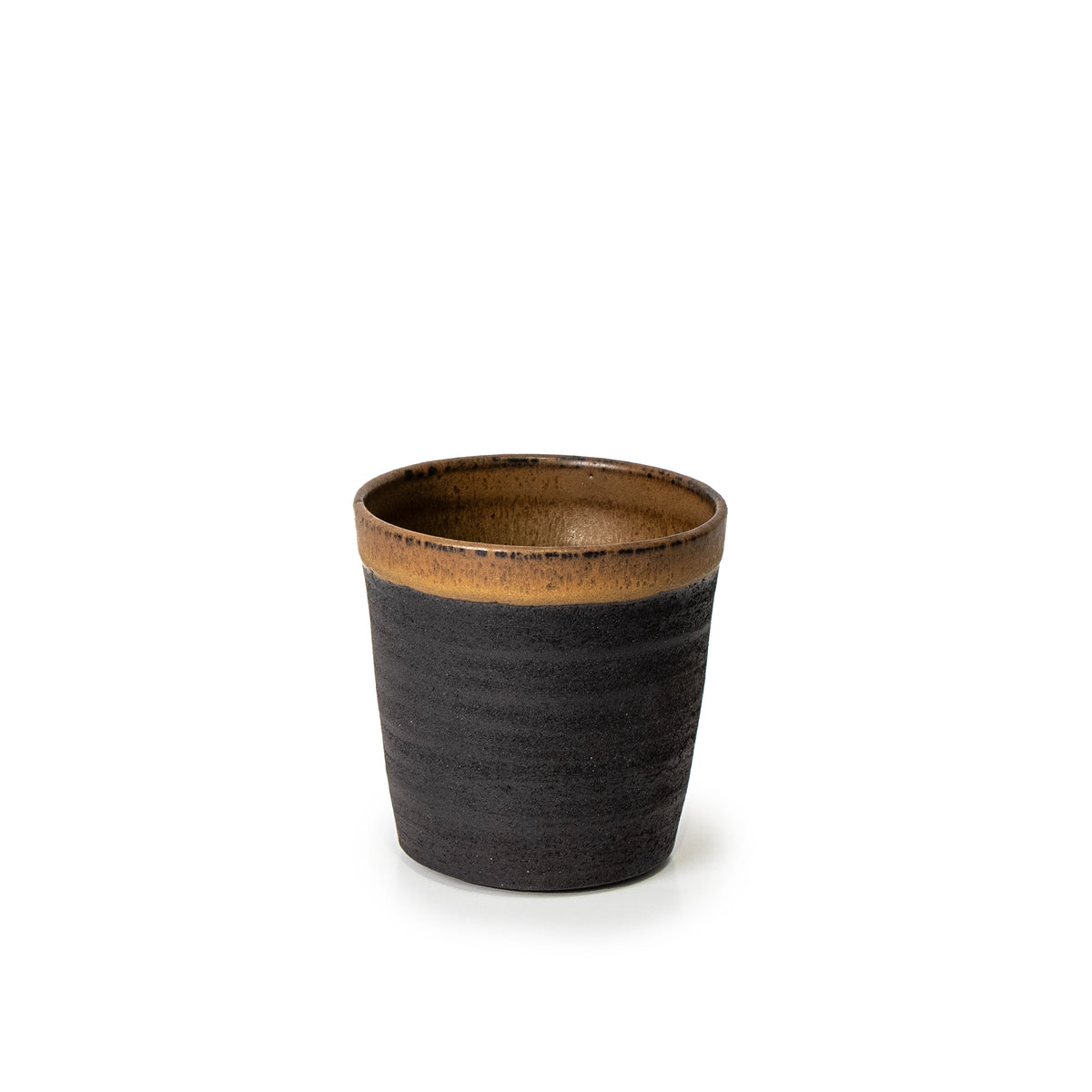De AB Ceramics Beker Zwart Roodbruin 20 cl is een uniek handgemaakt keramisch kopje met een mat donkerbruine body en een glanzende, lichtbruine rand, van zwart steengoed klei, gepresenteerd tegen een witte achtergrond.