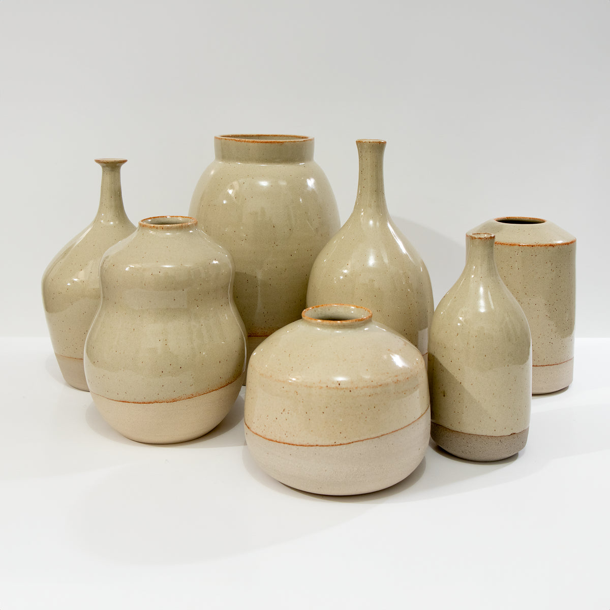 Zeven AB Ceramics Vaas Geel Beige H20,5 vazen van handgebakken beige keramiek met een glanzende, subtiel gespikkelde afwerking staan op een wit oppervlak tegen een effen witte achtergrond.