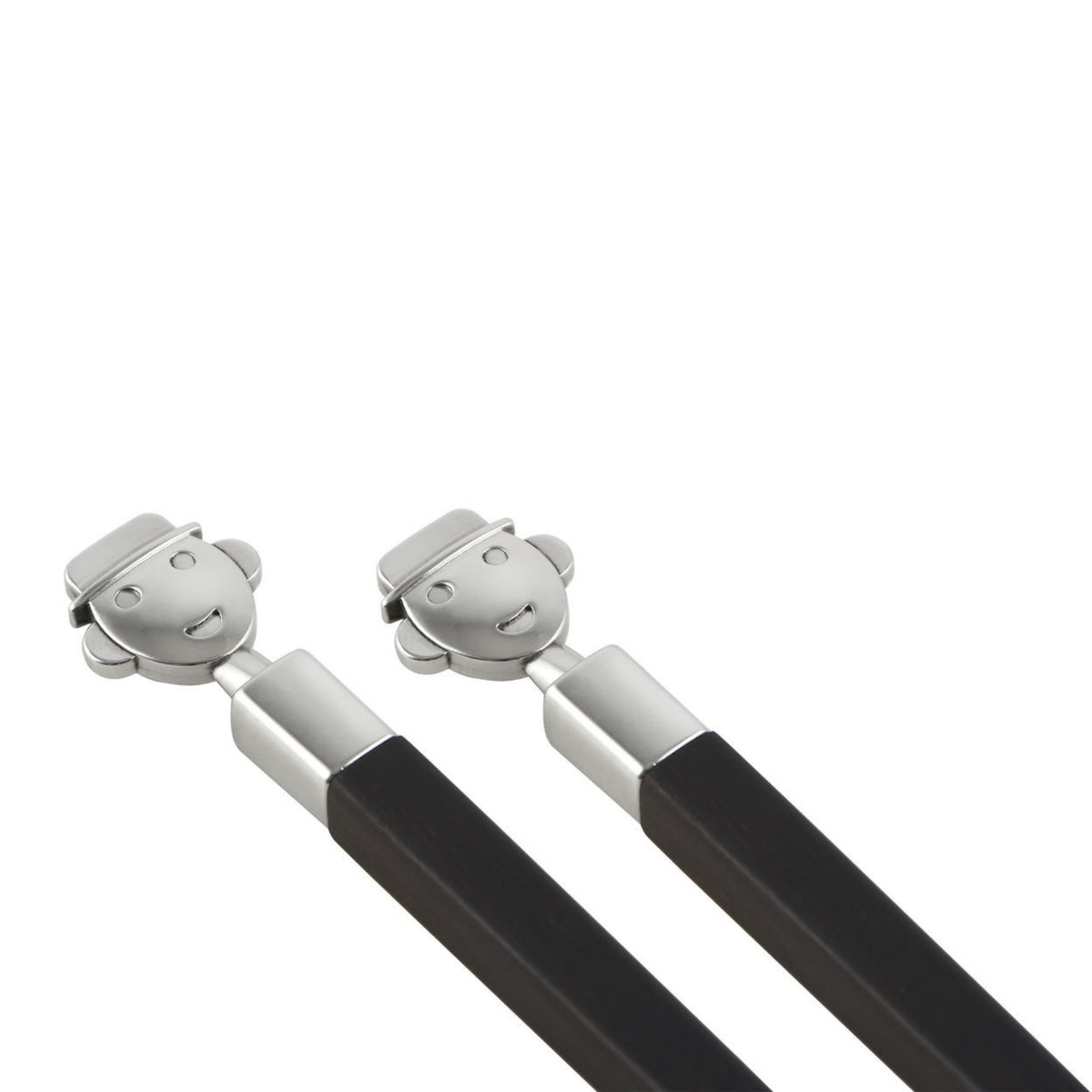 Een paar Alessi Alessandro Eetstokjes + Houder-zwarte design eetstokjes met zilveren uiteinden en lachende gezichtjes in hoedjes op de uiteinden, perfecte tafelaccessoires van Alessi.