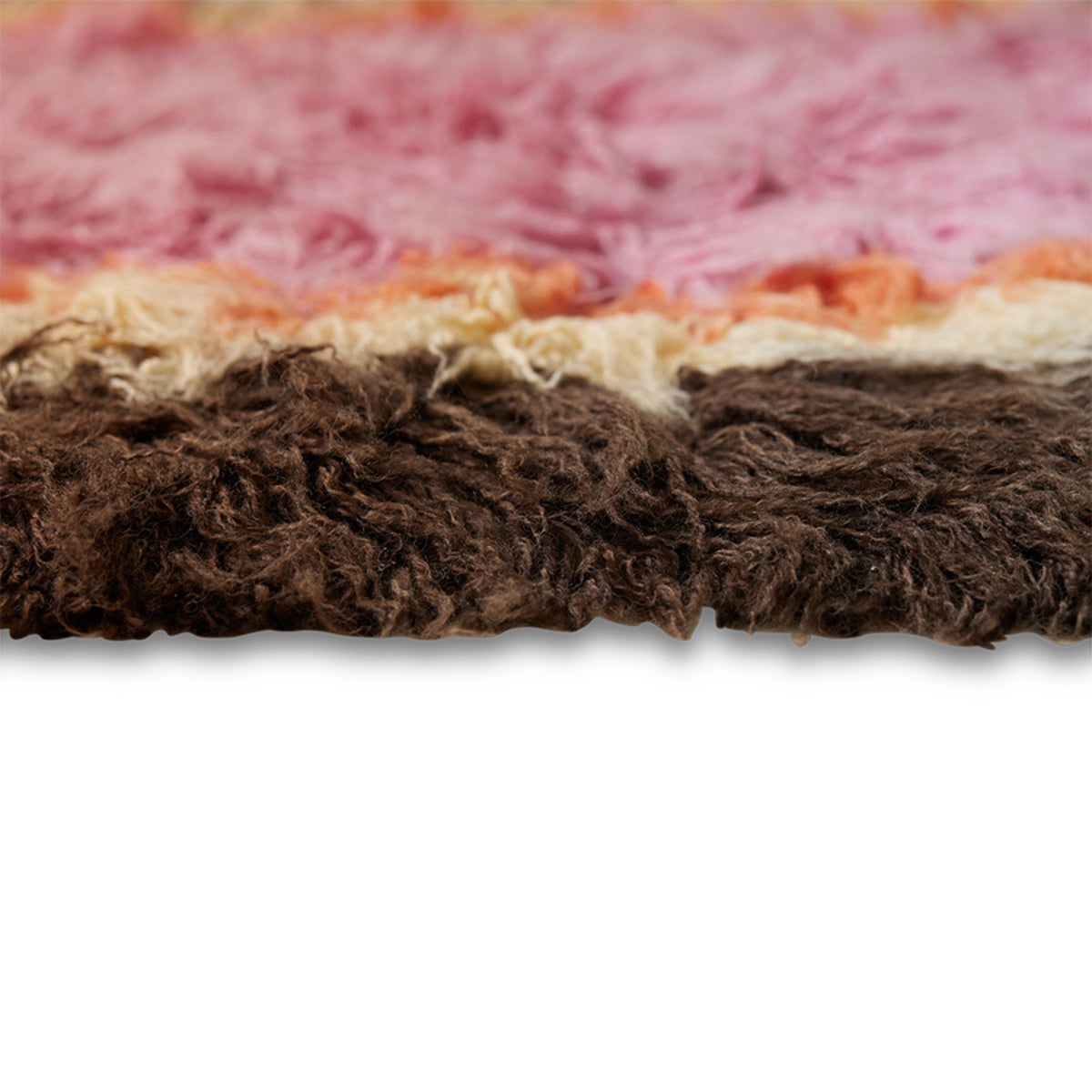 Close-up van de HK Living Fluffy Tapijt Downtown 180/120, met het gestructureerde, ruige oppervlak en de horizontale strepen in bruin, beige, oranje en roze tinten tegen een witte achtergrond.
