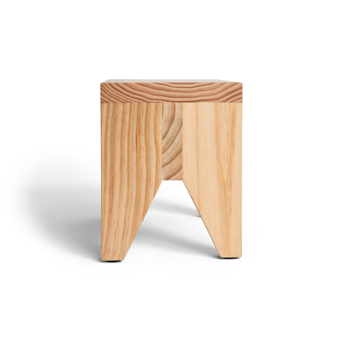 De Hay Manolito Kruk Bank Naturel Lang van Hay is een klein, minimalistisch houten krukje met een vierkante zitting, twee schuine poten en zichtbare natuurlijke nerfpatronen, afgebeeld tegen een witte achtergrond.