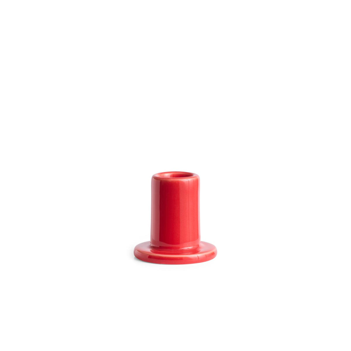 Een glanzend rode Hay Tube Kandelaar Rood van Hay, met een kleine cilindrische vorm en brede basis, is gecentreerd tegen een effen witte achtergrond.