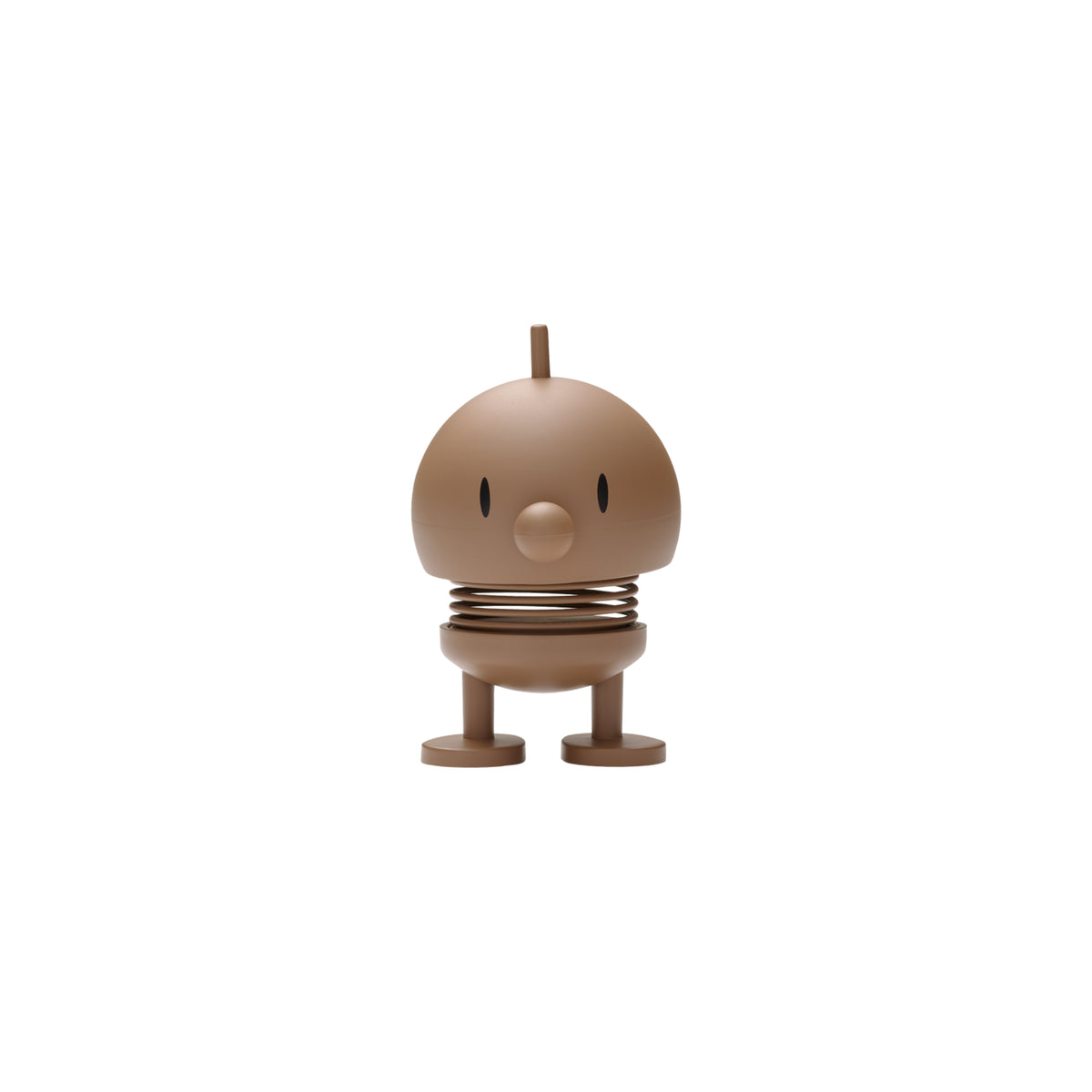 De Hoptimist Soft Bumble S Chocolate, een klein bruin rond figuurtje van Hoptimist met een eenvoudig gezichtje, snavelachtige neus, puntoogjes, veerkrachtig lichaam en korte beentjes met platte voetjes staat tegen een effen witte achtergrond-een charmant voorbeeld van Deens design.