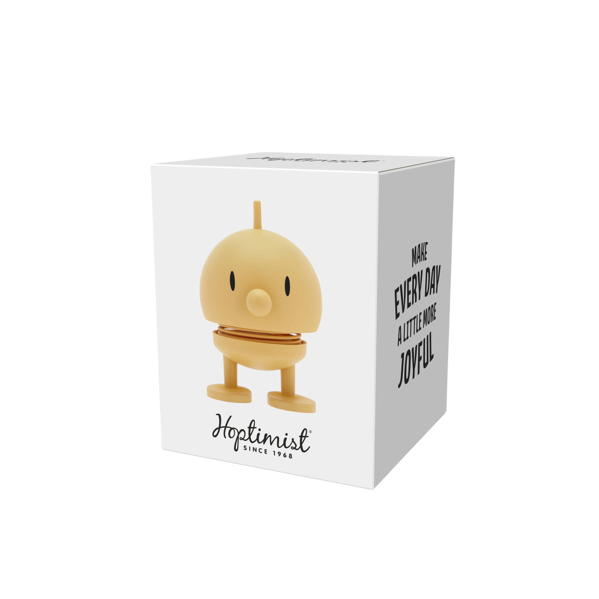 Een witte doos toont het gele, ronde Hoptimist Soft Bumble S Mimosa speelgoedfiguur, een klassiek Deens ontwerp. Op de voorkant staat het speelgoed met "Hoptimist Since 1968" en op de zijkant staat: "Maak elke dag een beetje vrolijker.