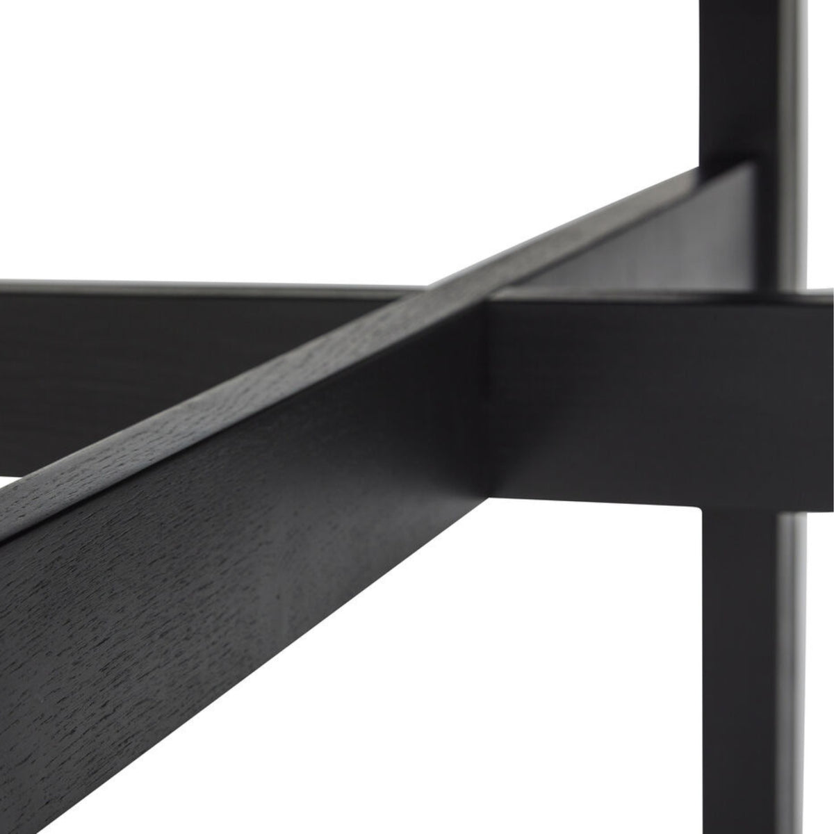 Close-up van kruisende zwarte balken van het Hubsch Fjord Eettafel Essenhout Zwart D120 frame, tegen een witte achtergrond.