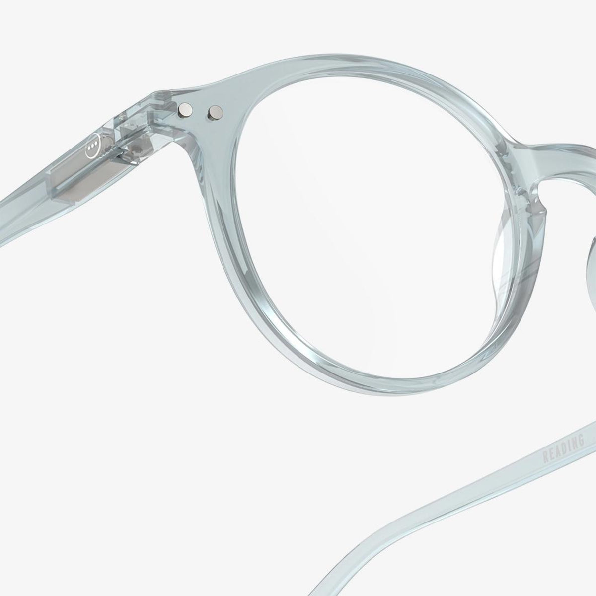 Close-up van transparant, rond Izipizi Leesbril #D Frozen Blue montuur tegen een witte achtergrond, met de linker lens en een deel van de veerarm van Izipizi, ontworpen voor comfortabele correctie van ouderdomsverziendheid.