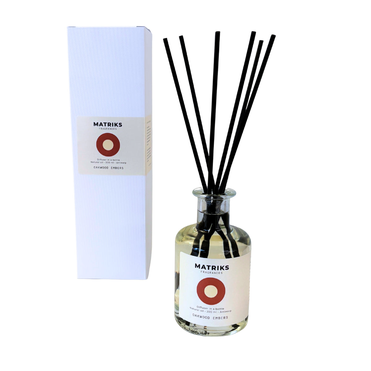 De Matriks Fragrances-geurverspreider Oakwood Embers 200 ml bestaat uit een heldere glazen fles met zwarte rietstokjes, gevuld met de lichte Oakwood Embers-vloeistof, en wordt geleverd in een hoge witte doos; beide zijn voorzien van het hoogwaardige Matriks Fragrances-label.