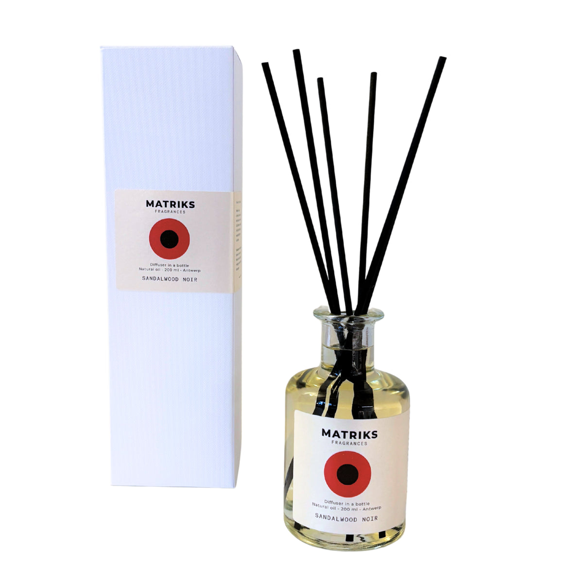 Naast een witte doos staat een fles Matriks Fragrances Diffuser Sandalwood Noir van 200 ml met zwarte rietstokjes. Beide zijn voorzien van een rood rond etiket met de tekst ‘Sandalwood No 12’ en zijn vervaardigd door Matriks Fragrances voor een elegante uitstraling.