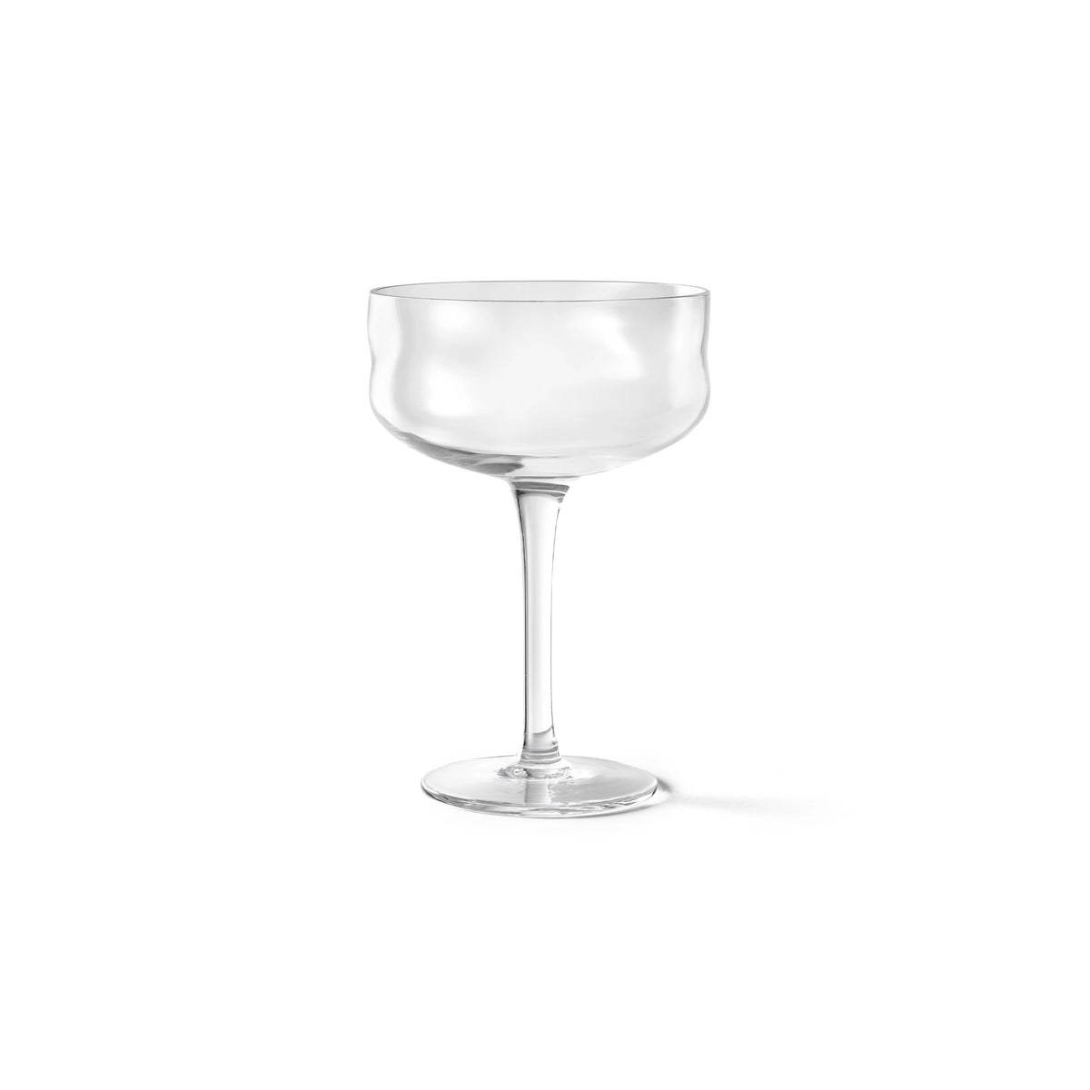 De Paveau Swirl Champagne Coupe Wave Helder 26 cl van Paveau is een heldere borosilicaatglas coupe met een korte steel en een brede, ondiepe kom, gepresenteerd tegen een effen witte achtergrond.