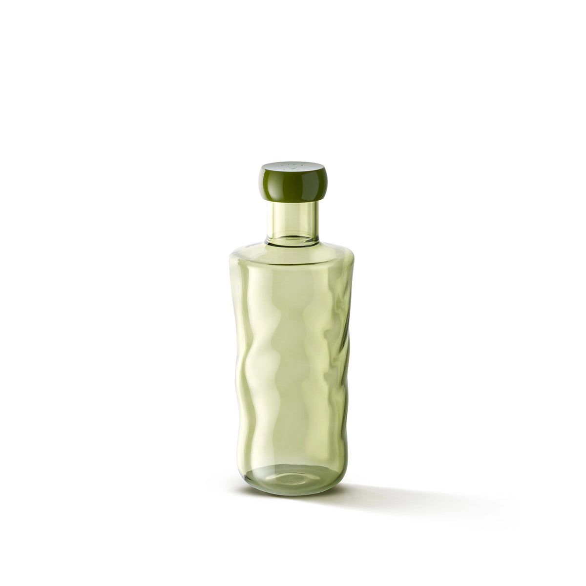 De Paveau Swirl Waterfles Moss Groen 0,75 l van Paveau is een doorschijnende lichtgroene fles gemaakt van duurzaam borosilicaatglas, met golvende zijkanten en een bijpassende ronde dop, rechtopstaand op een witte achtergrond.