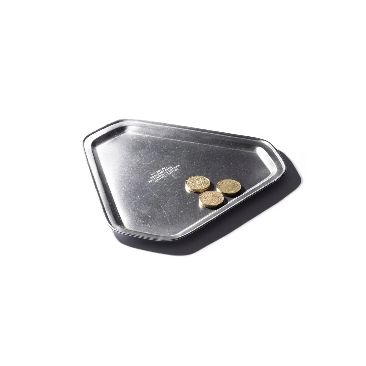 Het Puebco Iron Driehoekig Dienblad van Puebco, met drie goudkleurige munten erop, staat tegen een witte achtergrond met een schaduw naar rechts.