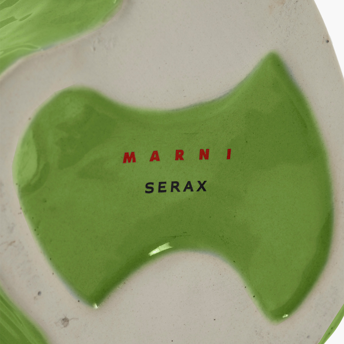 Close-up van de Serax Marni After Midnight Uil Vaas Lichtgroen S, een vaas van glanzend groen en gebroken wit keramiek. De merknamen "MARNI" in rood en "SERAX" in zwart staan op het oppervlak.