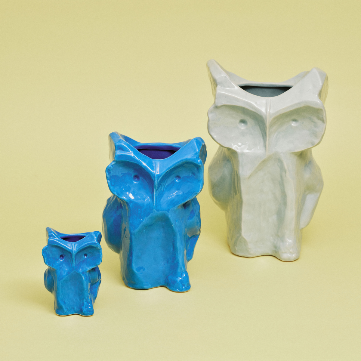 Drie keramische uilenvazen van Serax Marni After Midnight Uil Vaas Blauw XS, gerangschikt van klein naar groot op een lichtgele achtergrond, voegen charme toe als keramiek decoratieve vaasstukken.