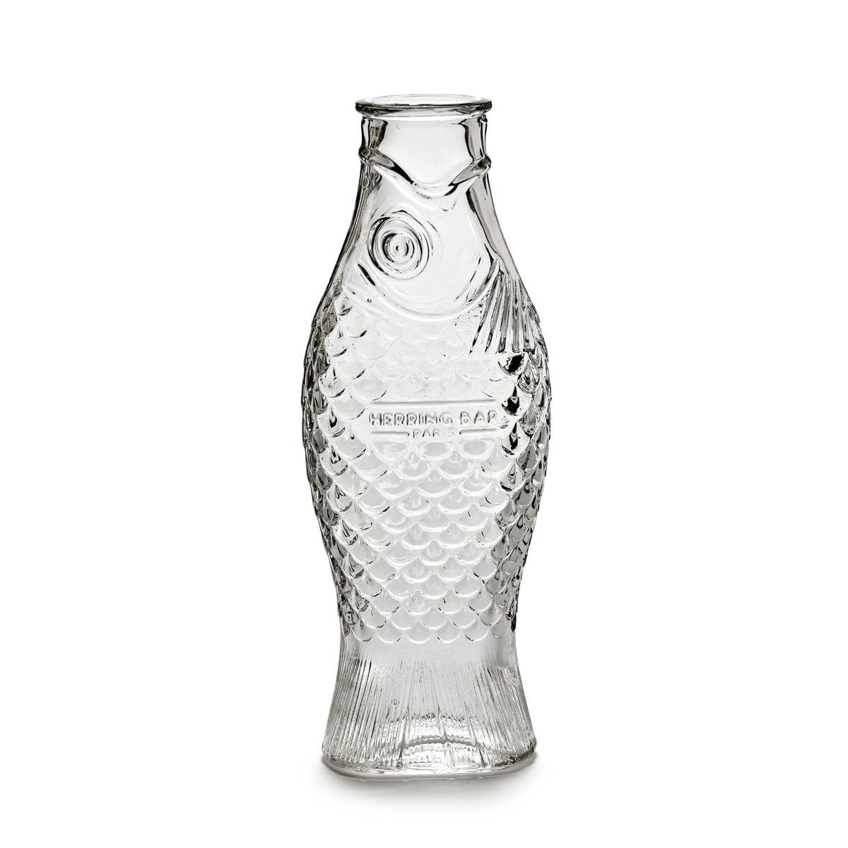 De Serax Fish & Fish Karaf Helder 85 cl, in de vorm van een vis met gedetailleerde schubben en vinnen, staat rechtop op een witte achtergrond.