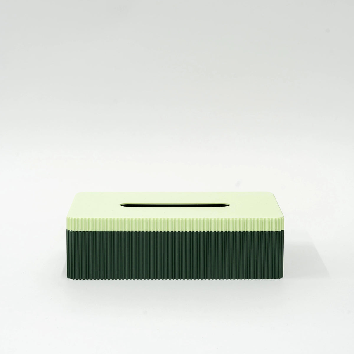 De Wavy Tissuebox Highland Groen/Munt van Wavy Design Studio heeft een rechthoekig, 3D-geprint ontwerp met een lichtgroene bovenkant en donkergroene geribbelde zijkanten, weergegeven op een effen wit oppervlak.
