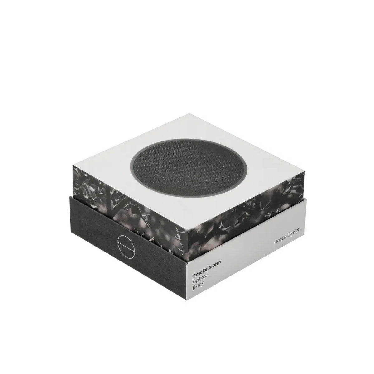 Een moderne vierkante doos toont een cirkelvormig zwart apparaat op het deksel, met het label Jacob Jensen Optical Rookmelder Zwart D10, een strakke zwart-witte rookmelder geïnspireerd op het minimalistische ontwerp van Jacob Jensen.
