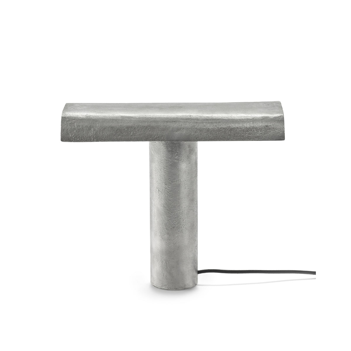 De Serax Fck Tafellamp Staal Grijs van Serax heeft een modern, minimaal ontwerp met een metallic grijze afwerking, T-vormig silhouet, cilindrische voet, horizontale lichtbalk bovenop en een zwart netsnoer vanaf de voet.