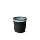 De AB Ceramics Beker Zwart Opaal 20 cl is een handgemaakte beker van zwart steengoed klei met matte buitenkant en glanzend blauwgroen glazuur, gemaakt in Antwerpen door AB Ceramics en gefotografeerd tegen een witte achtergrond.
