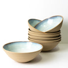 Een stapeltje van zes AB Ceramics Noodle Kom Geel Opaal D19 kommen met een matte bruine buitenkant en glanzende lichtblauwe binnenkant - ideaal als noodle bowl set voor je AB Ceramics handgemaakte serviescollectie.