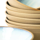 Een close-up van de AB Ceramics Noodle Kom Geel Opaal D19 van AB Ceramics, met een gladde bruine buitenkant en geglazuurde blauwwitte binnenkant - perfect als noedelkom - tegen een witte achtergrond.