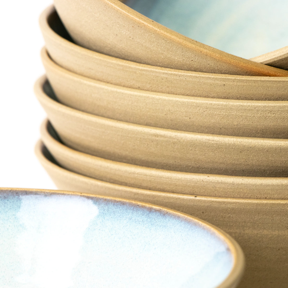 Een close-up van de AB Ceramics Noodle Kom Geel Opaal D19 van AB Ceramics, met een gladde bruine buitenkant en geglazuurde blauwwitte binnenkant - perfect als noedelkom - tegen een witte achtergrond.