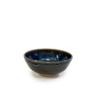 De AB Ceramics Mini Kom Wit Blauwbruin D10,5 is een handgedraaid steengoed kommetje met een glanzende donkerblauwe binnenkant en matte donkerbruine buitenkant, van AB Ceramics, getoond tegen een witte achtergrond.