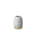 Het AB Ceramics Vaasje Wit Opaal is een klein, handgemaakt wit steengoed vaasje van AB Ceramics. Het heeft een glanzende opaal lichtgrijze bovenkant en een matte beige onderkant, gefotografeerd op een effen witte achtergrond.