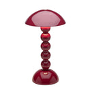De Addison Ross Bobbin Lamp LED Oplaadbaar Kersenrood is een moderne draadloze lamp met een glanzende kersenrood afwerking, een koepelvormige kap en een basis van gestapelde bolvormige segmenten op een afgeronde onderkant - gemaakt door Addison Ross.