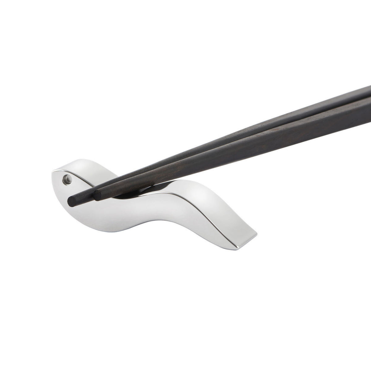 Een paar Alessi Anna eetstokjes rust op een slanke, zilveren vogelvormige houder tegen een witte achtergrond - een elegant tafelaccessoire van Alessi.