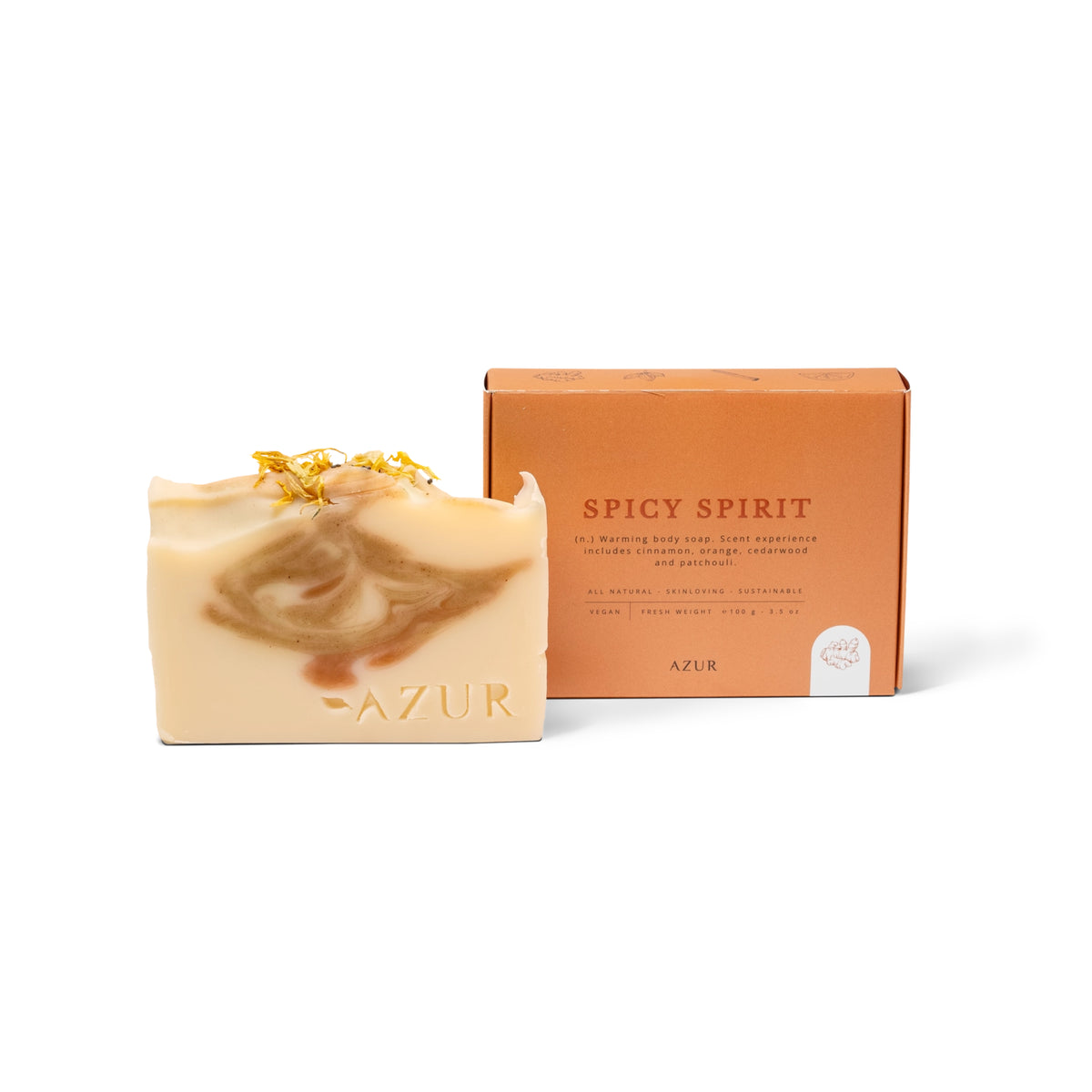 De Azur Spicy Spirit Natuurlijke Zeep Bar, handgemaakt in bruine en crèmekleurige swirls, ligt naast een oranje doos van Azur. Verrijkt met kurkuma en gedroogde bloemblaadjes voor een warme, natuurlijke uitstraling.