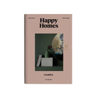Het Cozy Publishing Happy Homes Creative Boek is een lifestyle koffietafelboek met een beige kaft, gestapelde boeken, een vaas en abstracte muurkunst op een donkergroene achtergrond - ideaal voor fans van Scandinavisch design van Cozy Publishing.