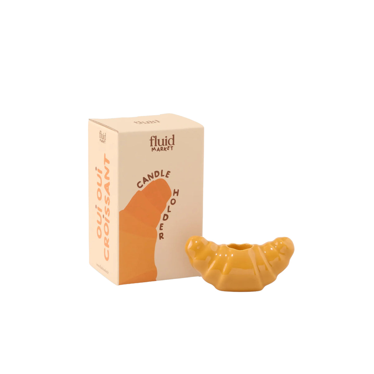 De Fluid Market Croissant Kandelaar in geel wordt getoond naast de verpakking, met het label KAARshouder OUI OUI CROISSANT. Dit keramische stuk van Fluid Market geeft elke ruimte een speels accent.
