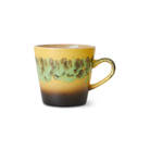 De HK Living 70s Ceramics Americano Mok Kelp is een keramische mok met een kleurverloop in geel, groen en bruin, een gespikkeld patroon aan de bovenkant en een rond oor in bijpassende kleuren.