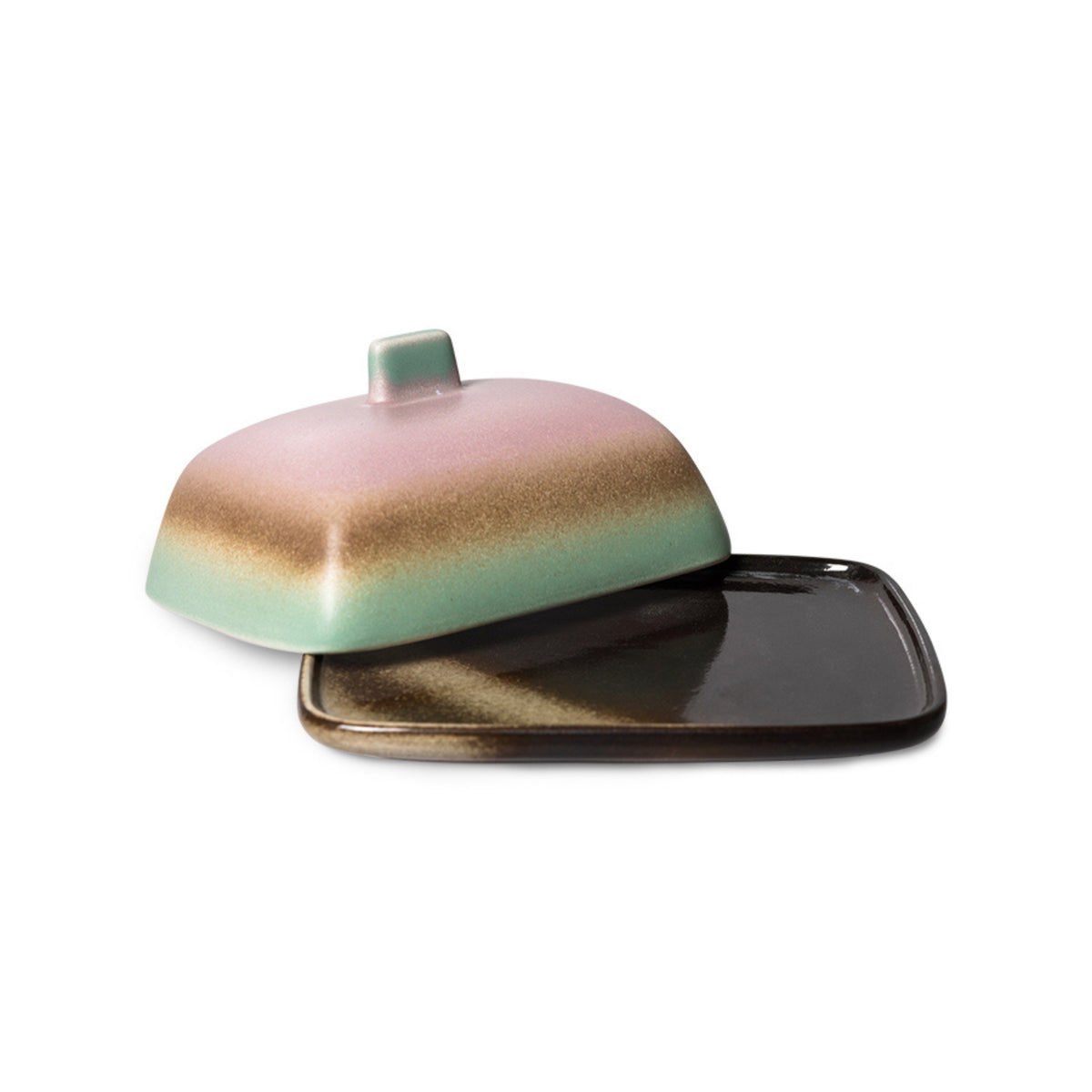 Het HK Living 70s Ceramics Botervlootje Mercury is een botervlootje van keramiek met een vierkante donkere basis en een afgeronde deksel, met retro-geïnspireerde roze, bruine en groene kleurverlopen en een klein handvat bovenop.