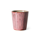 De HK Living 70s Ceramics Koffiekop Rabarber is een beker van keramiek met een glanzende, gestructureerde rabarberroze buitenkant en gladde rand, afgebeeld tegen een effen witte achtergrond.
