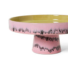 De HK Living 70s Ceramics Kom op Voet Bubble is een roze keramische cakestandaard met een stevige basis, gele binnenkant en zwart golvend druppelontwerp - een afspiegeling van de kenmerkende stijl van HK Living.