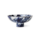 De HK Living 70s Ceramics Kom op Voet Indigo is een brede, ondiepe schaal van keramiek met een korte voet, voorzien van een blauw en wit gemarmerd patroon - een opvallend decoratief stuk van HK Living tegen een effen witte achtergrond.