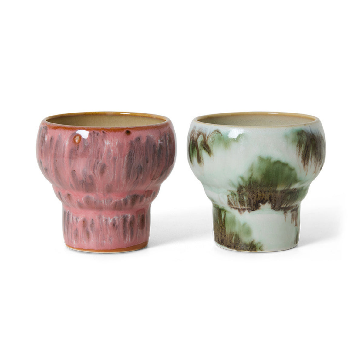 Twee HK Living 70s Ceramics Lungo Mokken Expression mokken met gestructureerd oppervlak: een roze geglazuurd met bruine accenten, de andere wit met groen. Beide hebben een brede rand, smalle voet en worden verkocht als set van twee.