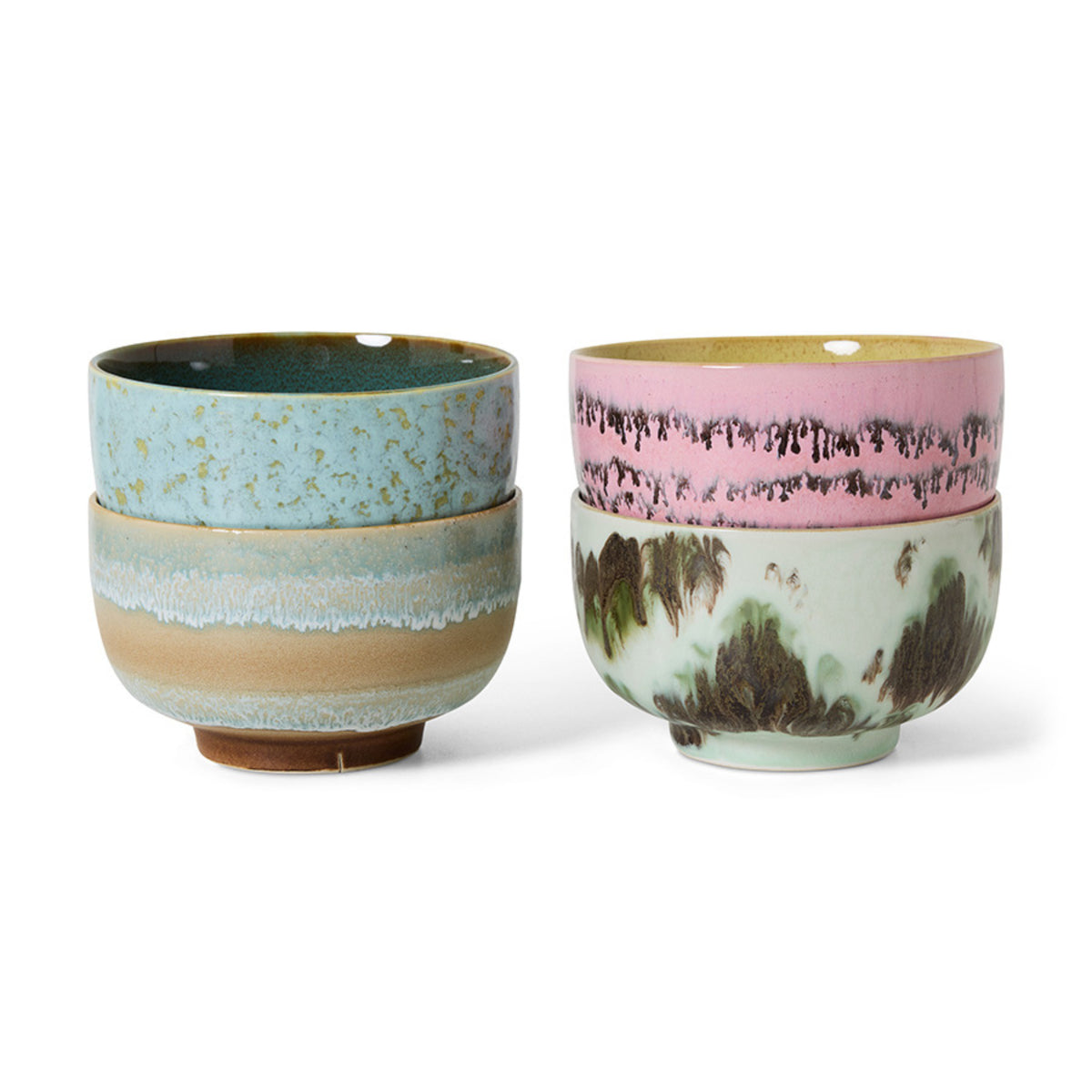 Vier HK Living 70s Ceramics Noodle Kom Dada D13 kommen zijn per twee gestapeld: de linkerset in blauw en bruin, de rechterset met een groene kom met aardse patronen en een roze kom met donkere spikkels - perfecte handgemaakte kommen.