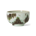 De HK Living 70s Ceramics Noodle Kom Tide D13 heeft een lichtgroen glazuur met bruine, getextureerde abstracte patronen, een gladde, ronde vorm en een korte, iets uitlopende voet die de kenmerkende jaren 70 stijl van het merk weerspiegelt.