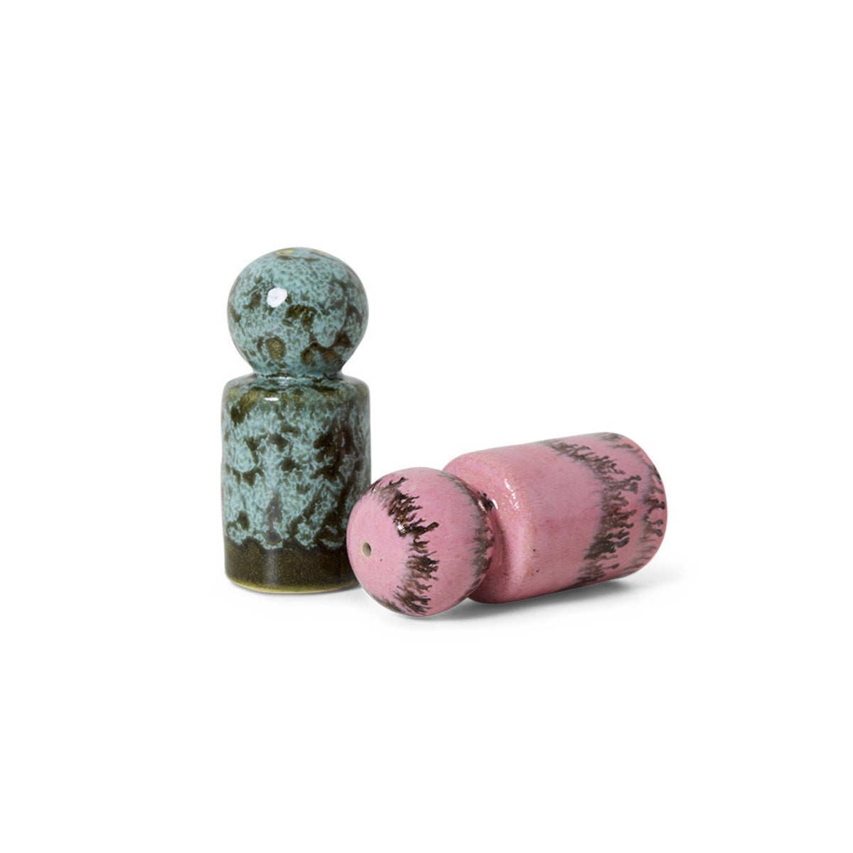 Er worden twee HK Living 70s Ceramics Peper- en Zoutvaatje Barok 2 st. getoond: een rechtop in gevlekt groen en blauw, de ander liggend in roze met donkere accenten, beide rond en cilindervormig, op een witte achtergrond.