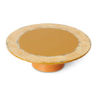 De HK Living 70s Ceramics Plateau/Taartschaal Papaya heeft een brede, platte mosterdgele bovenkant en een stevige basis. De gespikkelde crème en grijze rand geven deze handgemaakte HK Living taartschaal een unieke, opvallende uitstraling.