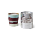 Een HK Living Kerst Special Geurkaars Frosted Leaves met blauwe, witte en kastanjebruine strepen staat naast een glanzend zilveren cilindervormige pot met het label "70s Ceramics Christmas Special Frosted Leaves" van HK Living.