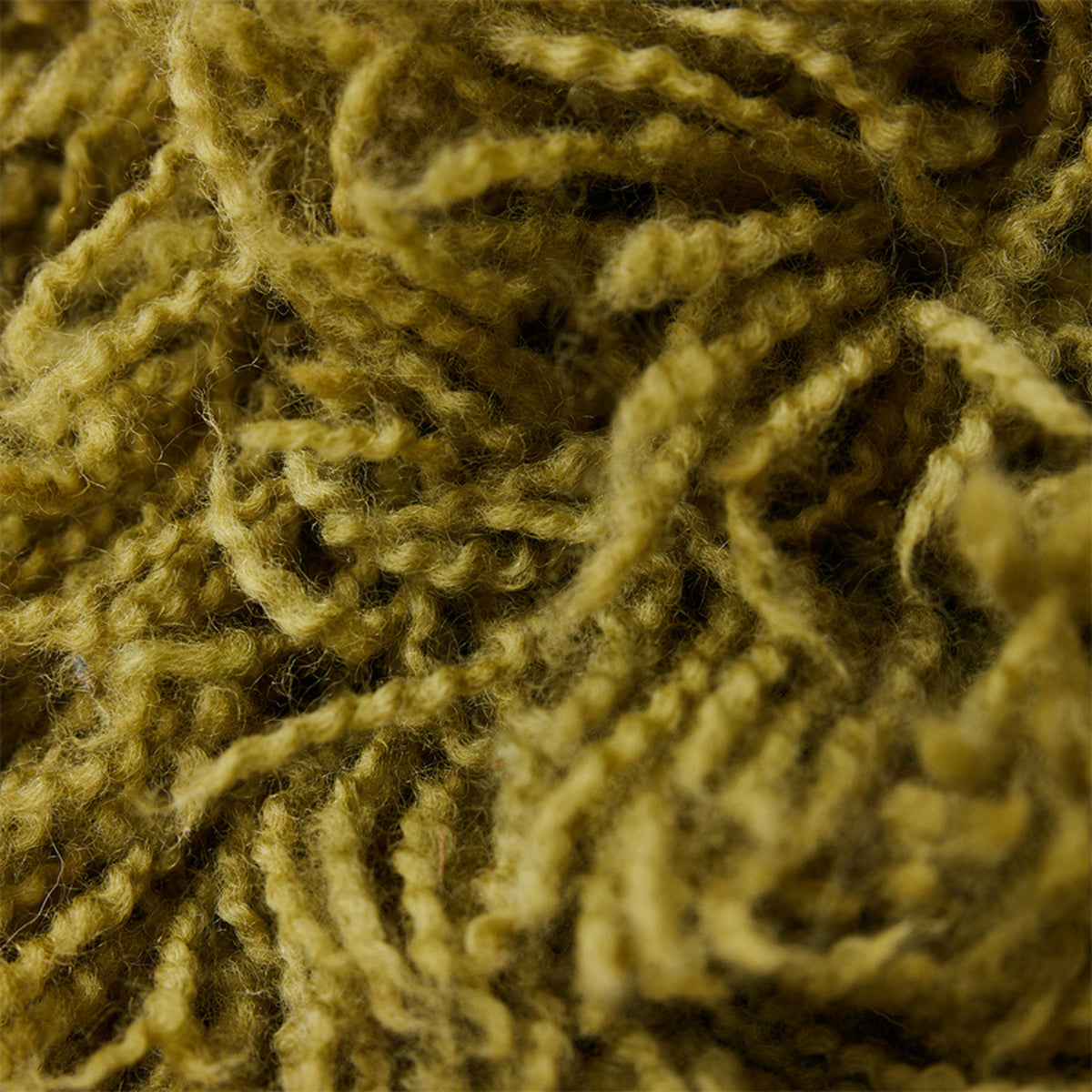 Close-up van dichte, krullende geelgroene vezels in de HK Living Rugged Kussen Olijfgroen 50/50, die de ingewikkelde textuur en rijke olijfgroene tint van HK Living laten zien.
