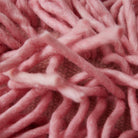Close-up van dik, zacht roze garen in een los, hoogpolig patroon benadrukt de donzige textuur en tactiele details van het HK Living Rugged Kussen Roze 70/45 kussen.