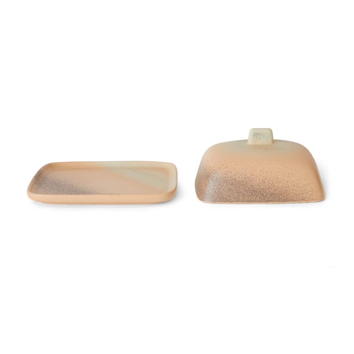 Het HK Living 70s Ceramics Botervlootje Breeze is een rechthoekig botervlootje van keramiek met een bijpassende deksel in bruin en beige gespikkelde tinten, met een retro vierkant handvat, geïnspireerd op vintage jaren 70 ontwerpen.