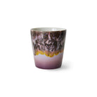 De HK Living 70s Ceramics Koffiekop Blast is een beker van keramiek met een glanzende afwerking, met een paars en bruin gemarmerd patroon aan de bovenkant en een vloeiend verloop naar lichtpaars aan de onderkant, tegen een witte achtergrond.