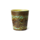 De HK Living 70s Ceramics Koffiekop Tidal beker heeft een glanzend, getextureerd glazuur in bruin, groen, blauw en geel met een organisch gemarmerd patroon op een witte basis voor een retro vibe geïnspireerd door het HK Living merk.