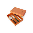 De HK Living Kaasmesjes Kust 3 st. set bestaat uit drie kaasmessen, elk met een uniek zwart, groen of wit handvat, gerangschikt in een oranje HK Living doos-ideaal voor het serveren op je favoriete kaasplank.