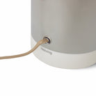 Close-up van de HK Living Lounge Tafellamp Chromen voet, met metallic afwerking, witte rand, met stof bekleed snoer en het hkliving logo aan de onderkant.